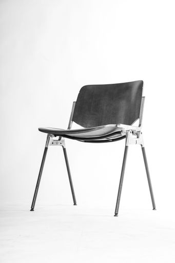 A vertical shot of a black corporate chair isolated on a white background