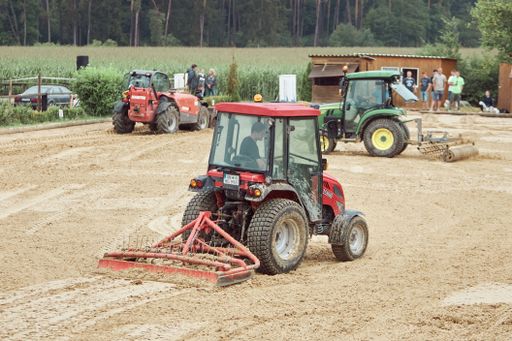 People preparing an equestrian court after heavy rain during a tournament in Bruenst, Bavaria, Germany