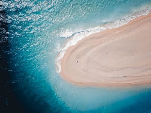 One tourist alone on top of Zlatni rat beach in Bol, Island Brac, Croatia, Europe. Also called golden horn or golden cape. April, 2021.