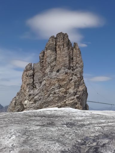 A Beautiful Natural stone tower hill covered with snow in Swiss alps of  Mount Titlis, Engelberg, Switzerland . Cloud behind the hill against blue sky
