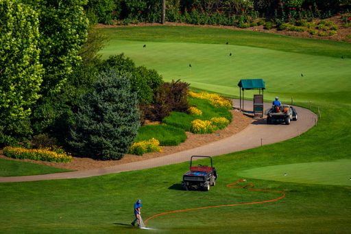 A picture of a golf course located on the outskirt of Beijing, people were taking care of the grass