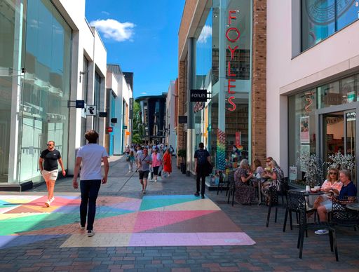 People walking and sitting outside a cafe in Bond Street, Chelmsford, Essex, UK.