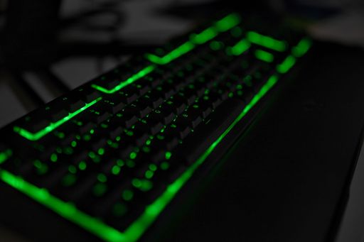 A closeup shot of a razer gaming keyboard with bright green lights
