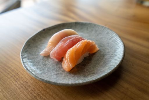 A closeup shot of salmon, tuna, and yellowtail pieces of sushi at a Japanese restaurant