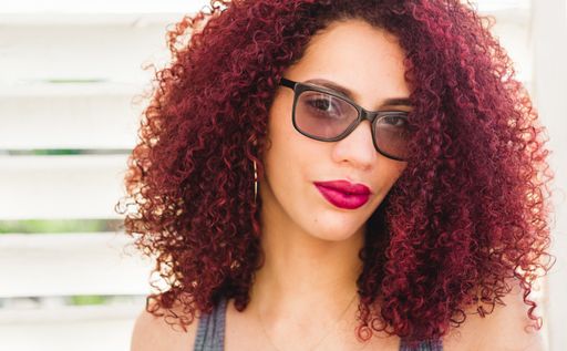 A beautiful Afro American woman with curly red hair posing for the camera