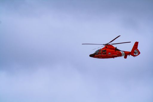 A beautiful shot of red Coast Guard helicopter in the blue sky on the Oregon coast.