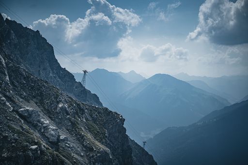 A beautiful view of cable wires over a rocky landscape on a cloudy day