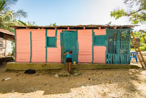 Santo Domingo / Dominican Republic - April 13 2014: Brown Woman Using Black Shorts and Entering into a Pink House