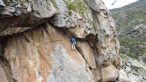 An adult male from behind hiking a mountain during daytime