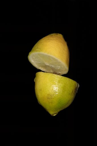 A vertical shot of yellow lemon slices isolated on black background