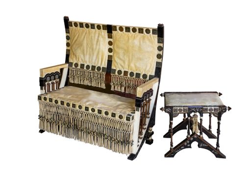Art Nouveau chair and side table designed by Carlo Bugatti around 1900. Made of ebonised wood, copper, pewter, parchment and bone.  Isolated on white.