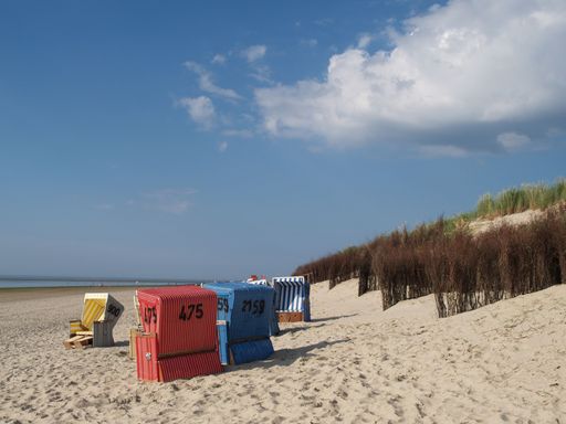 A sandy shore with multiple beach chairs. Langeoog, Germany.
