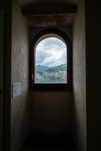 A vertical shot of window overlooking Lake Garda and mountains in Malcesine, Italy