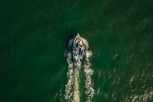 An aerial shot of fishermen on boats sailing in the ocean and leaving Belize City