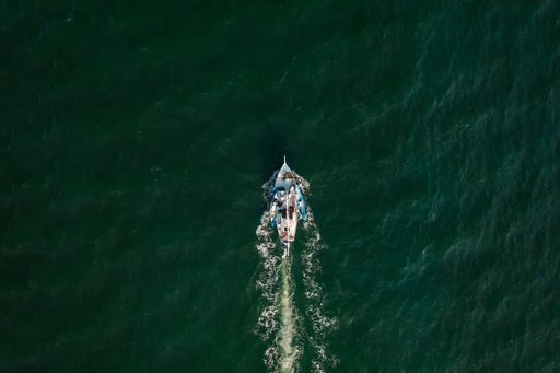 An aerial shot of fishermen on boats sailing in the ocean and leaving Belize City