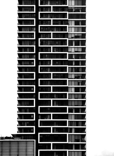 A vertical black-and-white shot of a residential building block isolated on a white background