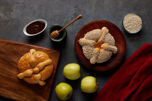 A top view of baked goods with honey, jam and apples