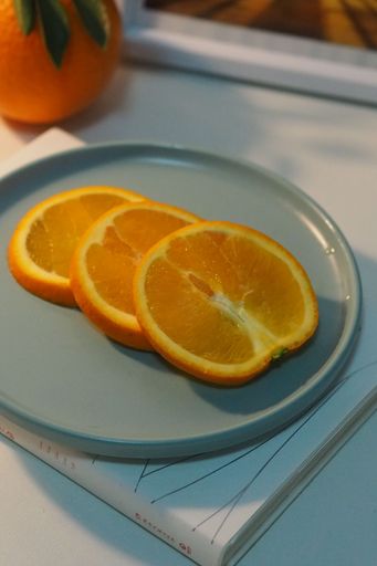 A sliced orange on a gray modern plate