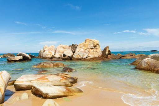 Rocky coast near blue ocean under calm sky