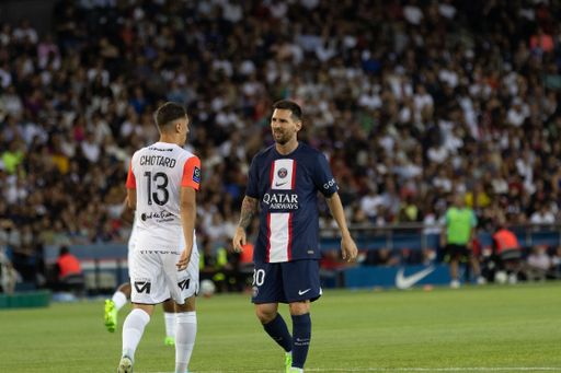 The player Lionel Messi facing another player from Montpellier