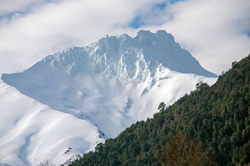 A scenic view of a breathtaking mountains covered in snow on a beautiful winter day