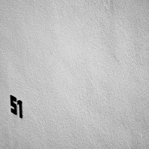 A grayscale closeup of number 51 on a textured wall