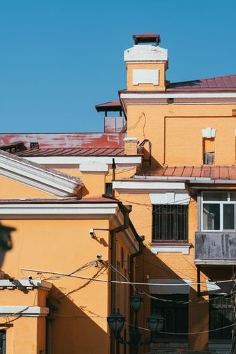 A vertical shot of orange buildings in a neighborhood with blue sky in the background