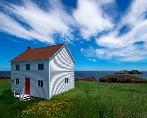 A white cottage on the shore of the ocean in Newfoundland and Labrador, Canada