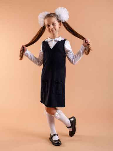 A portrait of a cute young girl wearing a school uniform and holding her hair