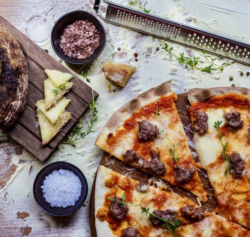 A top view of a homemade delicious pizza on a kitchen table