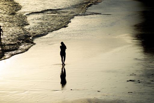 The people walking on the sand of Rio Vermelho beach in Salvador, Bahia, in the late afternoon
