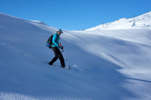A closeup shot of a Caucasian man near the mountains in winter in Valais, Switzerland