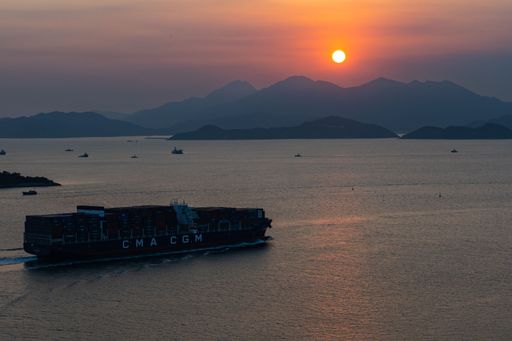 Sunset over sea with a container cargo ship sailing in it at Lamma Island, Hong Kong