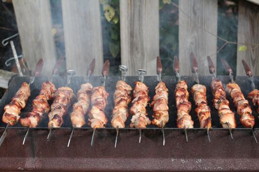 A shot of delicious barbecue on the skewers being fried on a grill brazier
