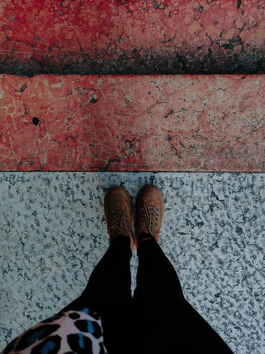 A high angle shot of the feet of a person standing on the floor under the lights