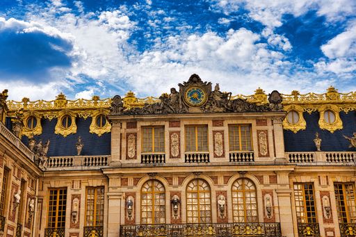 A low angle shot of the exterior facade of the historic Palace of Versailles in France