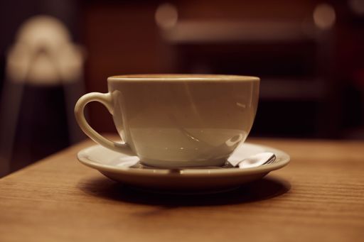 A closeup shot of a cup of coffee on a wooden table