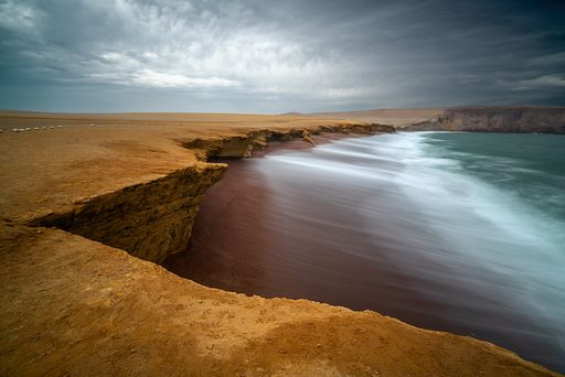 The coast and red sand beach of Paracas National Reserve in Peru