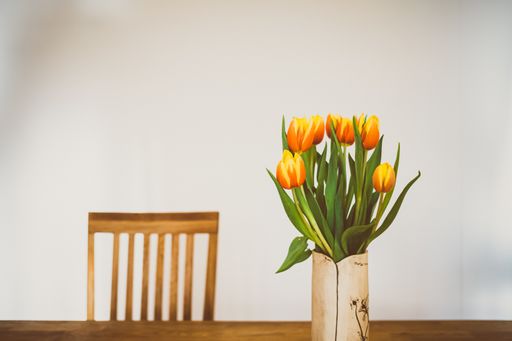 A selective focus shot of beautiful yellow and red tulips in a vase