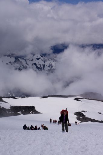 A vertical shot of adventurous hikers walking in Mount Rainier National Park, Washington state, during winter