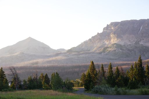 A beautiful scenery of mountains surrounded by a forest in Glacier National Park, Montana