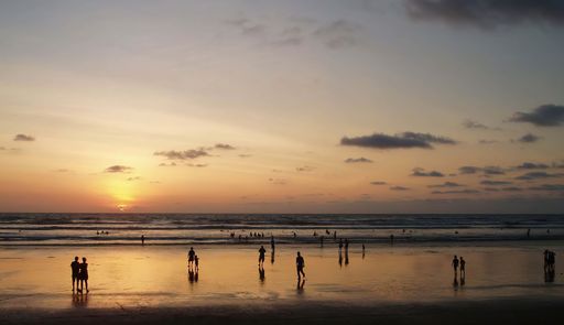 A silhouette of people on the Canoa beach during the sunset