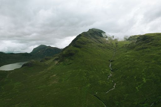 A beautiful view of hills and a small lake on a cloudy day in Bla Bheinn