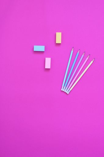 top view of pastel colored pencil and eraser on bright pink background