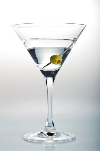 A vertical shot of a glass of Martini and an olive in it on a white background