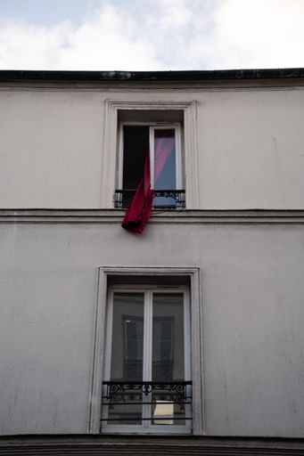A vertical shot of two glass windows on the facade of an apartment building in Paris, France
