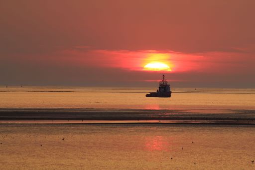 A beautiful shot of a sunset over a ship in the sea