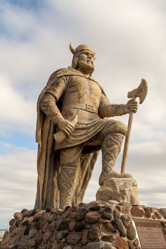Vertical view of old Viking statue on waterfront of lake Winnipeg in Gimli, Manitoba, Canada under cloudy sky