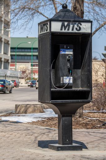 A vertical shot of an old telephone booth on a city street. Winnipeg, Canada