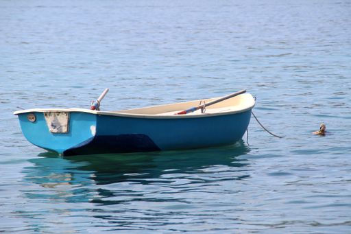 A sunny scenery of a fishing boat in a reflective sea